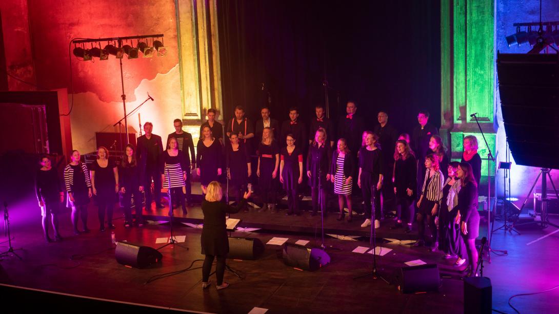 Der Jazzchor Chornfeld auf der Bühne, mit viel buntem Licht